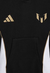 Sudadera negra con acentos dorados y un bolsillo frontal. Presenta una tela texturizada, paneles laterales diagonales en blanco y diseños de logotipos distintivos en el pecho.