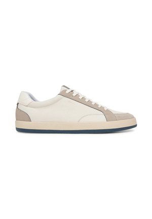 Sneaker basse in tela bianca e beige con lacci bianchi e suola beige su sfondo bianco.