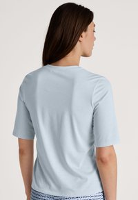 Lichtblauwe t-shirt met korte mouwen, gemaakt van zachte stof. Heeft een ronde halslijn en een relaxte pasvorm. Geen zichtbare patronen of accenten.