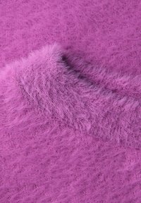 Chlupatá růžová látka s jemným, texturovaným povrchem. Vyznačuje se lehkým a vzdušným pleteným vzorem, zdůrazňujícím živou fialovou barvu.