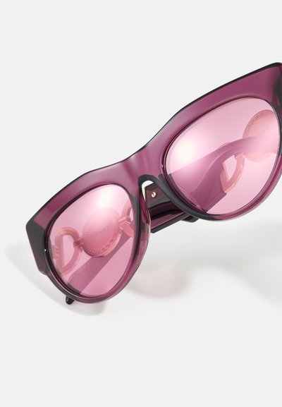 Ochelari de soare cu un design îndrăzneț și unghiular; ramă de un violet închis translucid; lentile roz reflective; detalii metalice cu logo.