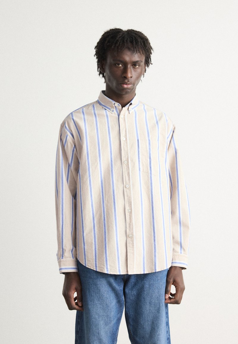 Gestreept button-up shirt in beige met blauwe strepen, voorzien van een kraag, lange mouwen en een borstzakje. Zachte stof met een relaxte pasvorm.