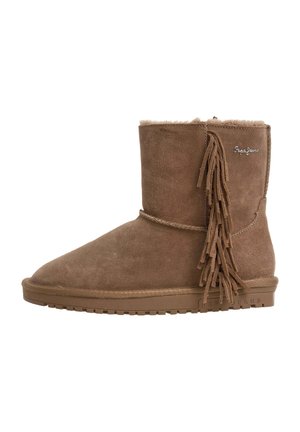 Botte mi-mollet en daim marron avec détails à franges sur le côté, semelle plate et doublure douce visible à l’intérieur.