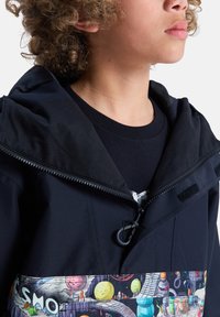 Zwarte jas met een ritssluiting aan de voorkant en een verstelbare capuchon, met een kleurrijk, grafisch paneel met een ruimte-thema aan de onderkant.