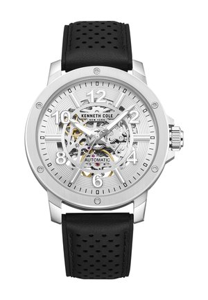 Silberne Kenneth Cole Automatikuhr mit schwarzem, perforiertem Lederarmband und sichtbaren mechanischen Zahnrädern im Zifferblatt, die die Uhrzeit 10:10:35 anzeigen.