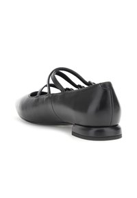 Schwarzer Leder-Ballerschuh mit niedrigem Absatz und drei dünnen, überkreuzten Riemen an der Oberseite, schräger Blick, der Rück- und Seitenansicht zeigt.