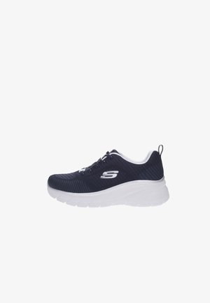 Zapatilla Skechers negra con suela blanca, parte superior de malla, cierre de cordones y logo en el costado, mostrada de perfil sobre fondo blanco.