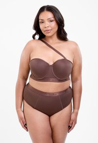 Brun strappy bh uden stropper med en enkelt skulderstrop og matchende høj'-midje trusser. Glat tekstur og diskret branding langs taljebåndet.