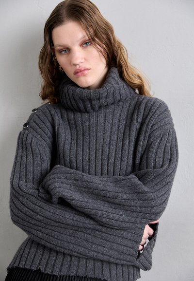 Suéter cinza canelado com um gola alta, mangas largas e detalhes em botão nos ombros, feito de um material de malha macia.