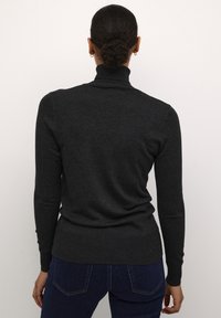 Ciemnoszary sweter z golfem, z długimi rękawami, dopasowany fason i prążkowane mankiety oraz dół. Gładka faktura, odpowiedni do noszenia na warstwy.
