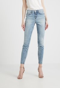 Ljust blå skinny jeans i denim med en blekt tvätt, med lätt slitage, fem fickor och dragkedja.