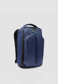 Mochila azul marino con un diseño elegante, fabricada con tela texturizada, que cuenta con un asa superior, compartimentos con cremallera y detalles en negro.