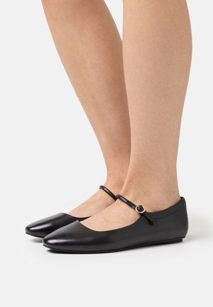 Ballerines en cuir noir avec bout arrondi, bride de cheville ornée d'un anneau doré, et finition lisse. Design profil bas.