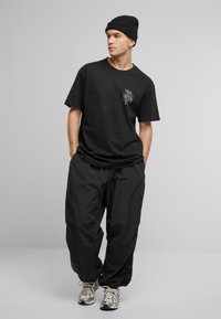Upscale by Mister Tee NOT LIKE US - Print T-shirt - black