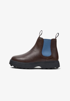 Bota Chelsea de cuero marrón con un panel lateral elástico azul, suela de goma y tiradores para facilitar su uso. Acabado texturizado con puntera redondeada.