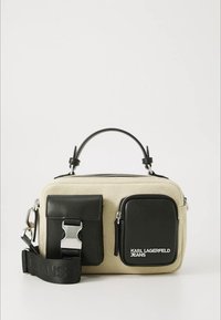 Lærreds taske med sorte læderdetaljer, top håndtag, lynlåslukning, to forlommer og en justerbar rem markeret med "JEANS."