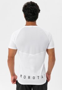 Hvid atletisk t-shirt med mesh rygdesign, korte ærmer, og "MOROTAI" trykt i sort ved sømmen.