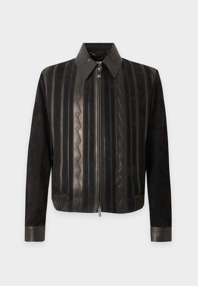 Veste bomber en cuir noir avec motifs rayés verticaux, fermeture éclair à l'avant, col pointu et poignets et ourlet bordés de cuir.