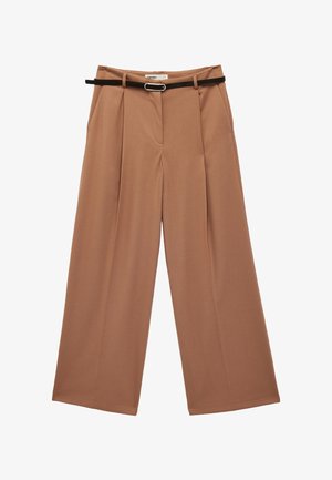 Wijd uitlopende broek in camelkleur met voorplooien en zijzakken, gecombineerd met een smalle zwarte riem met een zilveren gesp.