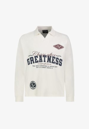 White long-sleeve polo shirt with collar, printed text "Chase after Greatness," and small logos on chest and lower front.