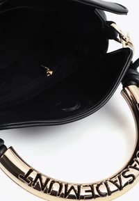 Černá kožená kabelka se zlatým kruhovým držadlem s embosovaným nápisem. Interiér zahrnuje kapsu na zip a hladkou podšívku.