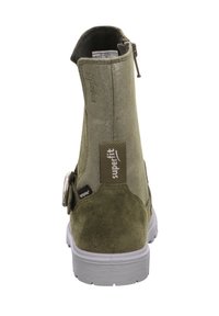 Zielone zamszowe botki za kostkę z detalem w postaci srebrnej klamry, teksturowanym materiałem, białą podeszwą i zamkiem z tyłu ułatwiającym zakładanie.
