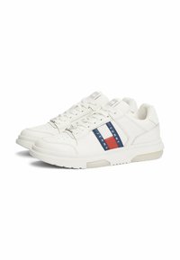 Sneakers bianchi in pelle con suola piatta, caratterizzati da strisce multicolori in blu mare, rosso e bianco. Design con lacci e dettagli con logo sulla linguetta.