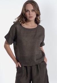 Bruine linnen top met een ronde hals en opgerolde korte mouwen, gecombineerd met bijpassende losse broek. Gemêleerde stof, ontspannen ontwerp.