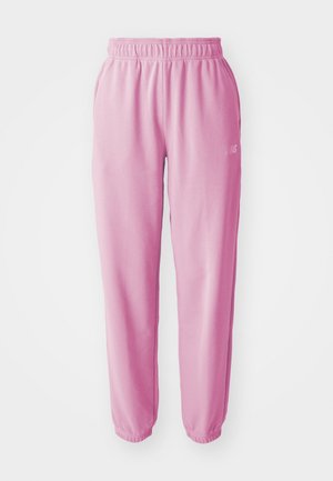 Pantalons de survêtement en tissu rose avec une taille élastique et des ourlets à revers. Présente un petit logo brodé sur le côté gauche. Texture douce.