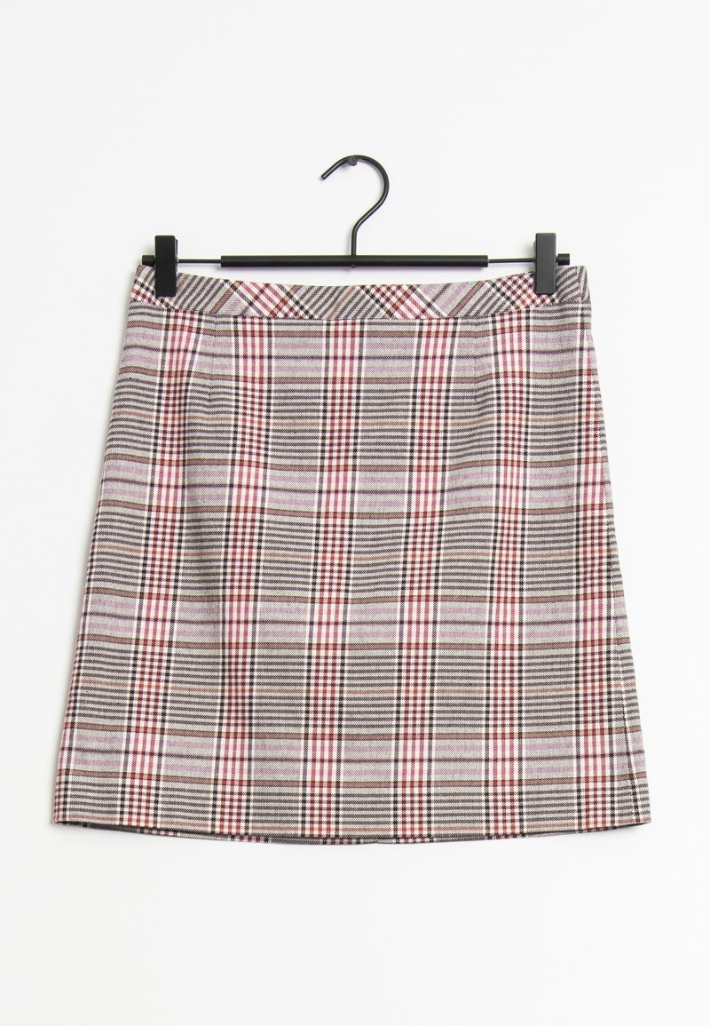 Jupe trapèze à carreaux en tons beige, marron et rouge suspendue à un cintre noir sur fond blanc.
