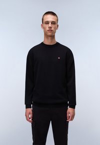 Zwarte sweatshirt met lange mouwen en een ronde halslijn, voorzien van een klein rood en wit logo op de borst. Vloeiende textuur, relaxte pasvorm.