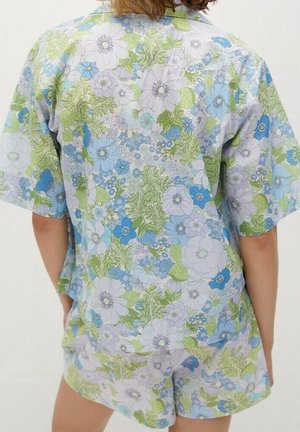 Ensemble de vêtements d'intérieur en coton à motifs floraux, comprenant un haut à manches courtes et un short aux couleurs bleu clair, vert et violet, ornés de grandes fleurs et feuilles.