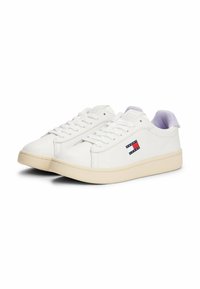 Witte leren sneakers met een platte crèmekleurige zool. Kenmerken zijn onder meer een laag ontwerp en een logopatch in rood, wit en blauw.