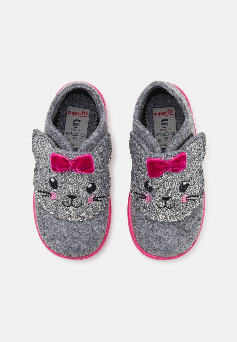 Chaussons pour enfants gris avec des visages de chat scintillants, joues roses, moustaches noires et nœuds en velours rose sur le dessus, semelles roses visibles.