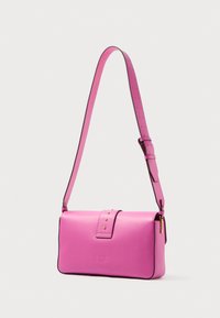 Rózsaszín bőr kereszttáska sima tapintással, fedelezettel és arany színű fém kiegészítőkkel. Állítható vállpánttal és kontrasztos szélekkel rendelkezik.
