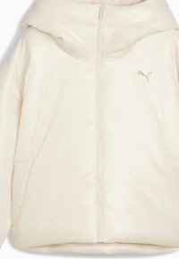 Ljust beige pufferjacka med full dragkedja, huva och sidofickor; tillverkad av slätt, glänsande material med en liten logotyp på bröstet.