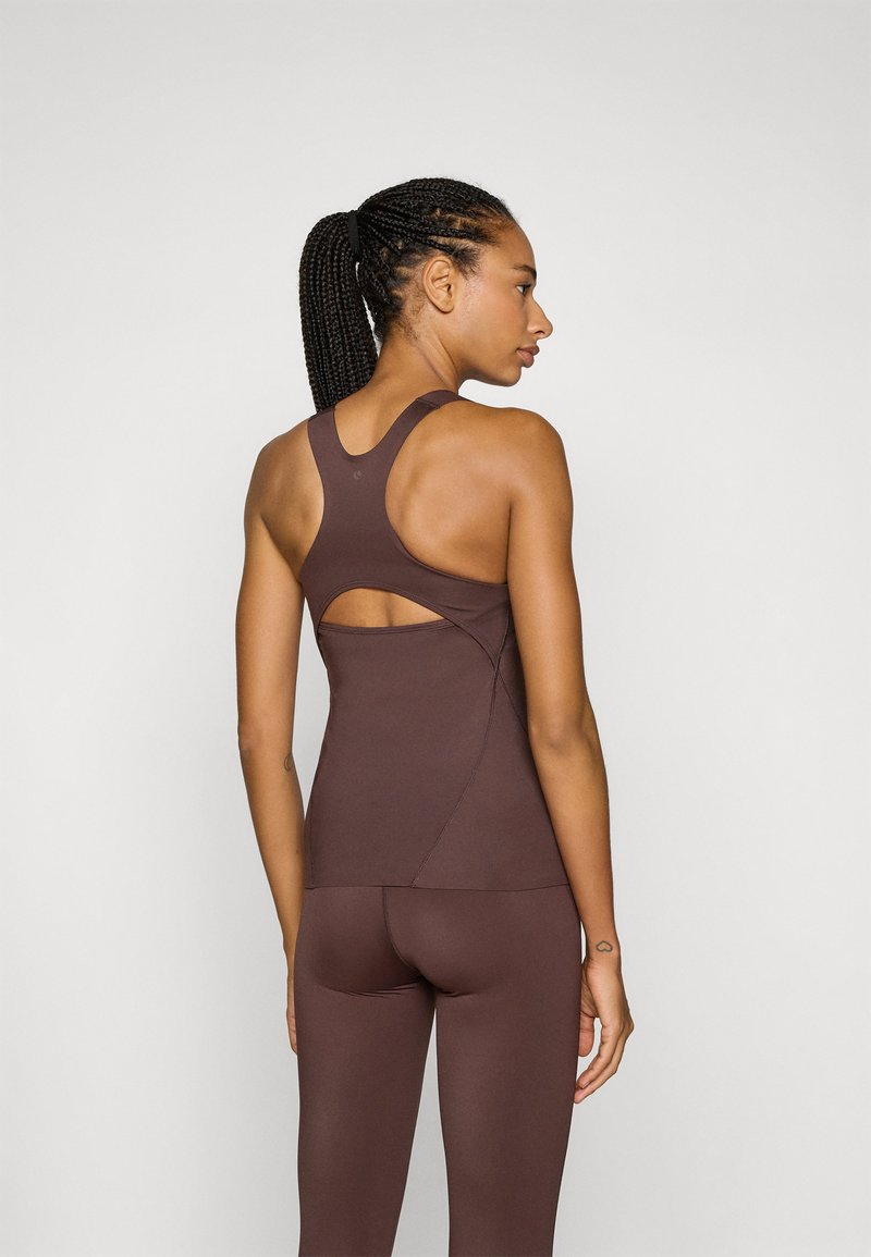 Bruine fitness tanktop met racerback ontwerp, met een uitsnijding aan de achterkant. Het materiaal lijkt glad en rekbaar.