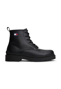 Bottine noire à lacets avec semelle épaisse et écusson logo Tommy Jeans sur le côté, conçue pour un usage décontracté et robuste.