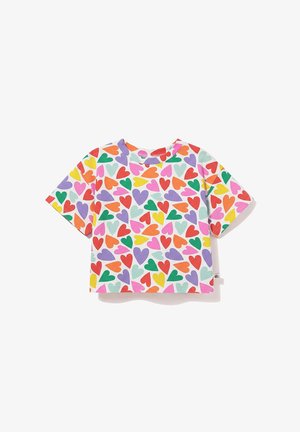 Biały krótki top, pokryty kolorowym wzorem serc w kolorach czerwonym, pomarańczowym, żółtym, zielonym, fioletowym, różowym i jasnoniebieskim.