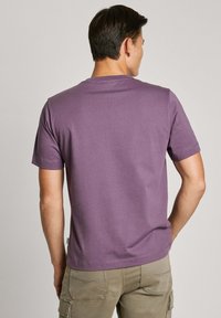 Violet trumpas rankovėmis marškinėliai pagaminti iš minkštos medvilnės, su apvaliu kaklu ir švariu dizainu be matomų raštų ar grafikų.