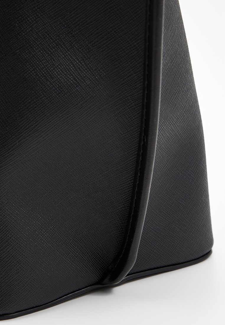 Borsa a tracolla nera texturizzata con una finitura liscia, caratterizzata da un design curvo e cuciture in contrasto lungo i bordi.