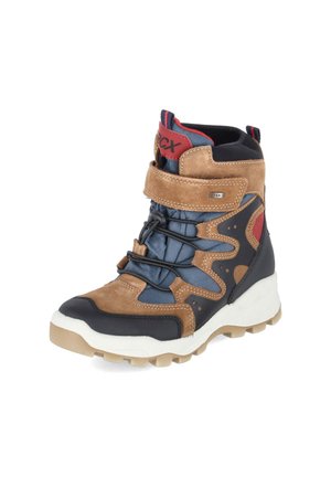 High-top brown and navy winter boot with padded ankle, Velcro strap, black elastic laces, red accents, and white rugged sole.
