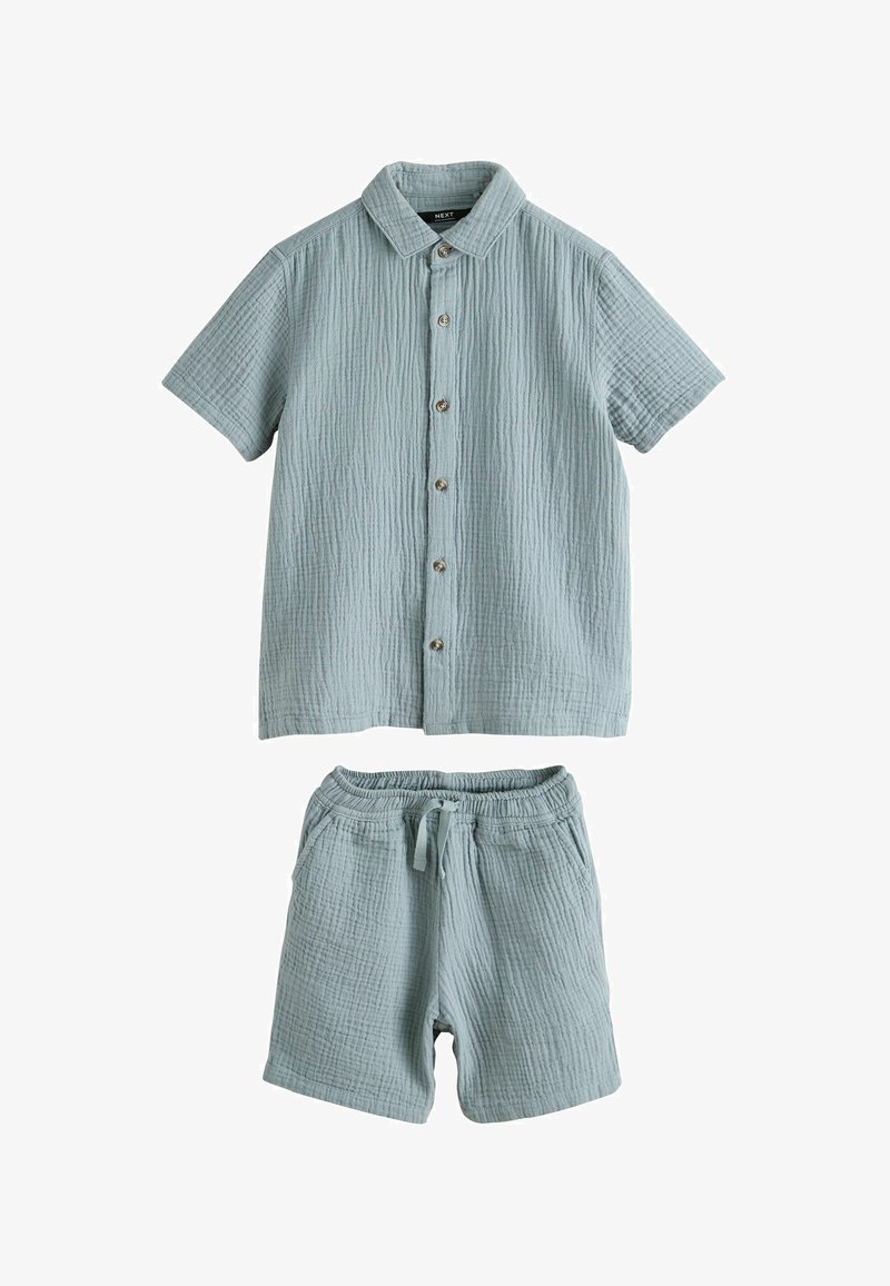 Chemise bleu clair texturée à manches courtes boutonnée, associée à un short assorti à taille élastique avec cordon et poches avant.