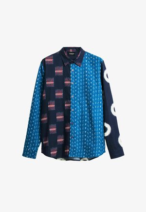 Chemise à manches longues à boutons avec motifs bleus mélangés : bleu foncé avec des carrés rouge-blanc, bleu vif avec de petits traits blancs, et bleu marine avec des cercles blancs.