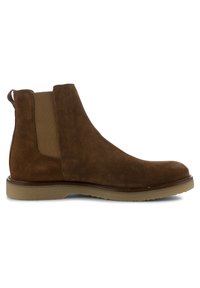 Bottine Chelsea en daim marron avec panneaux latéraux élastiques et semelle en caoutchouc, talon bas et languette à l'arrière.