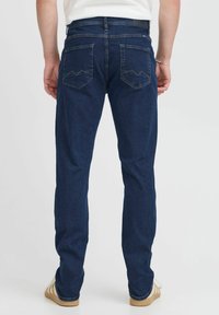 Mørkeblå denimjeans med rett snitt, med to baklommer med chevronmønster og en mid-rise midje.