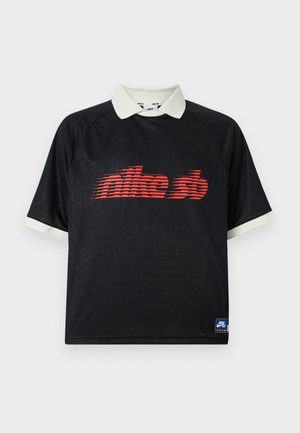 Czarna koszulka polo z krótkim rękawem, białym kołnierzykiem i mankietami, z czerwonym, zniekształconym logo "nike sb" na piersi oraz małą niebieską metką Nike SB u dołu.