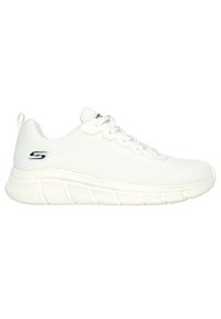 Zapato deportivo blanco con parte superior de malla texturizada, diseño curvado y suela de goma gruesa con ranuras verticales. Logo de acento en el lado.