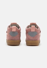 Růžové semišové boty s šedými akcenty, kulatým podpatkem a texturovanou gumovou podrážkou. Mají hladký interiér a minimalistický design.