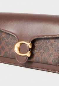 Portefeuille en cuir marron avec une surface à motif marron foncé, une fermeture en métal doré et des coutures contrastantes le long des bords.